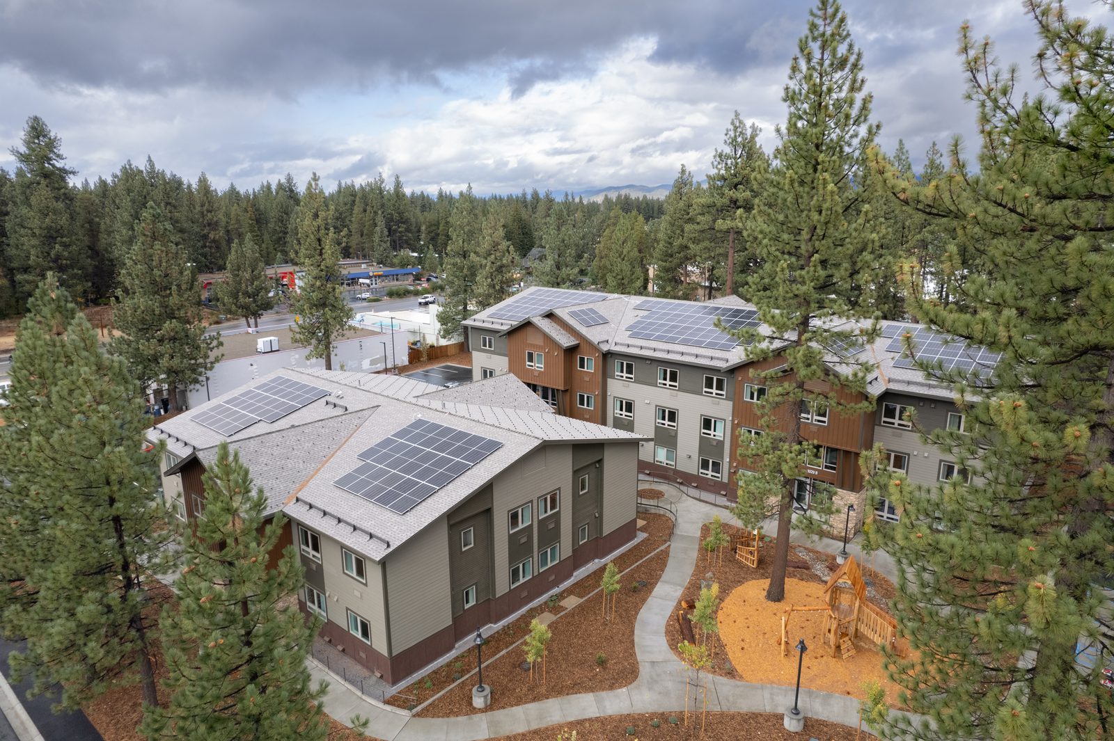Aerial view of a multi-family affordable housing development in the Tahoe Basin, surrounded by pine forest.